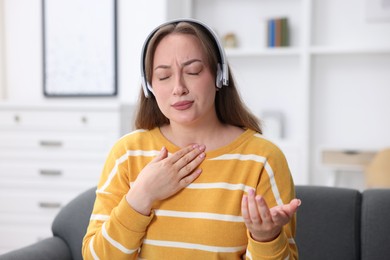 Photo of Woman in headphones having online consultation with doctor at home