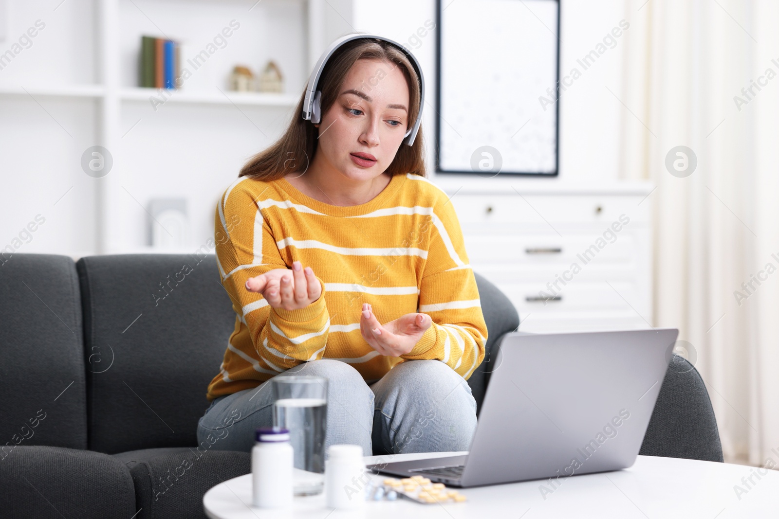 Woman in headphones having online consultation with doctor via laptop at home Photo of Woman in headphones having online consultation with doctor via laptop at home