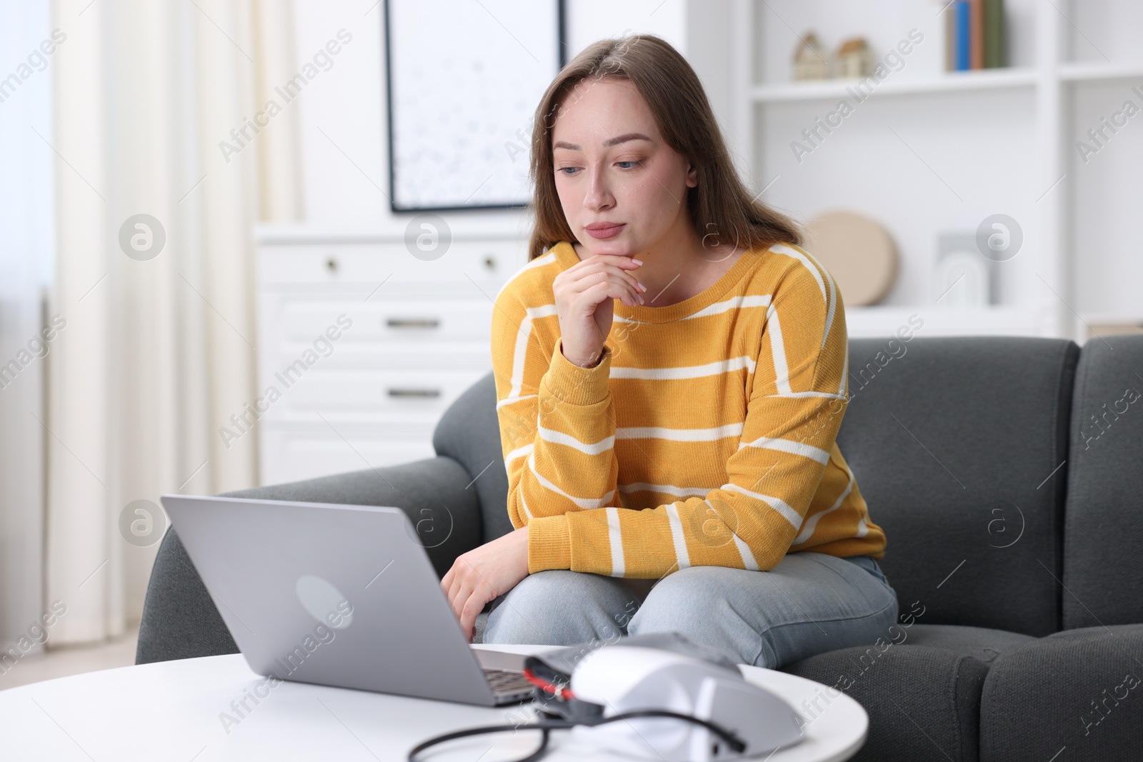 Photo of Woman having online consultation with doctor via laptop at home