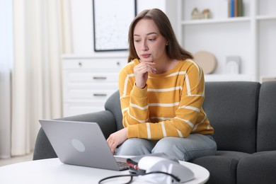 Photo of Woman having online consultation with doctor via laptop at home