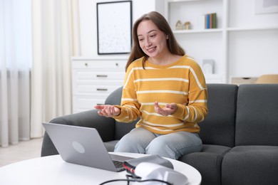 Photo of Woman having online consultation with doctor via laptop at home