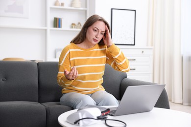 Photo of Sick woman having online consultation with doctor via laptop at home