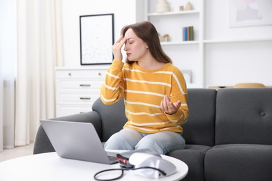 Photo of Sick woman having online consultation with doctor via laptop at home