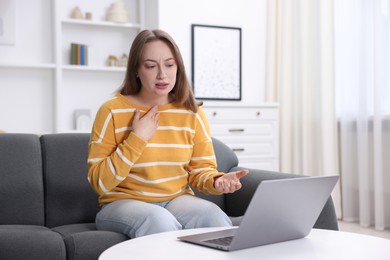Photo of Sick woman having online consultation with doctor via laptop at home