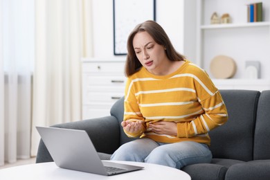 Photo of Sick woman having online consultation with doctor via laptop at home