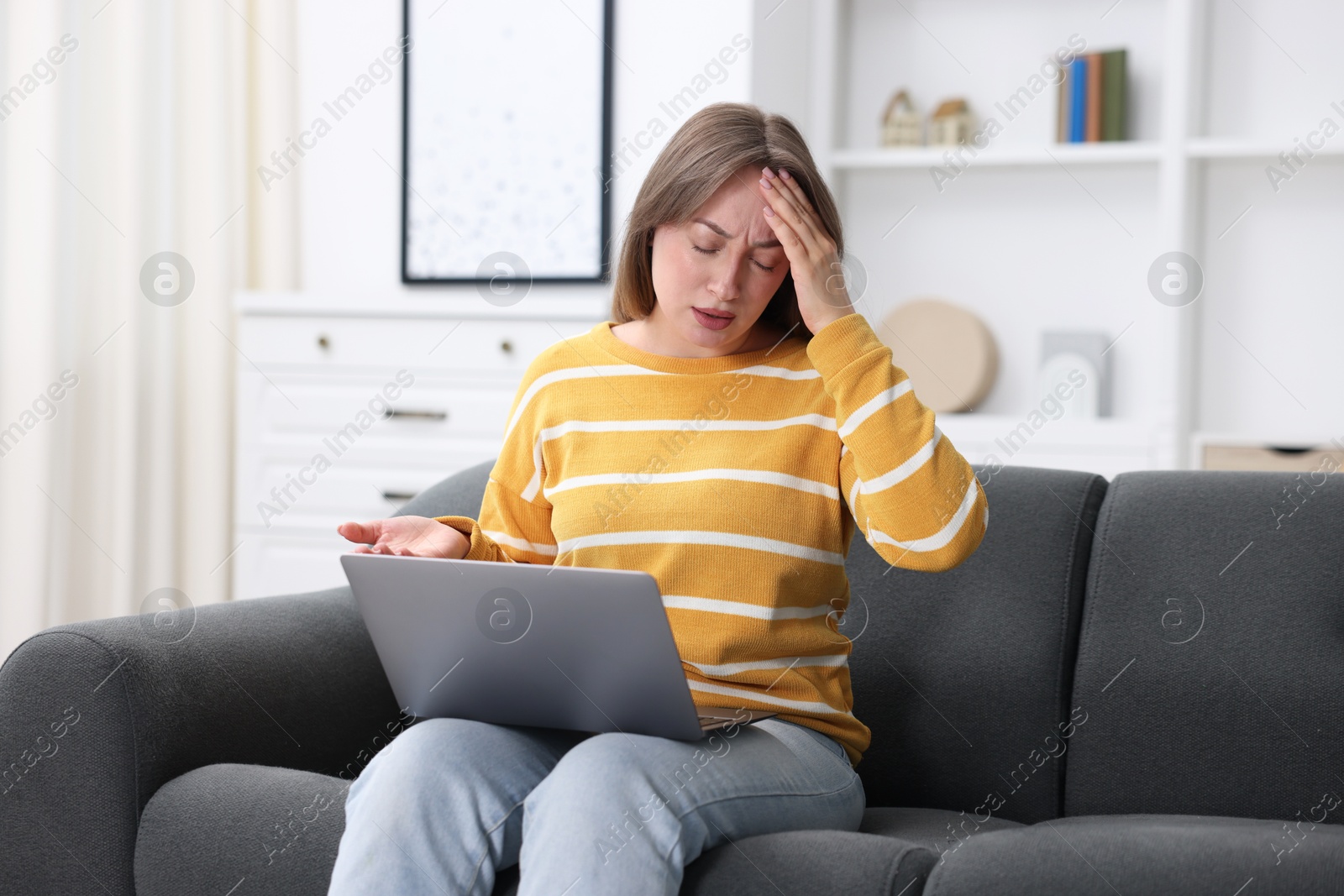 Sick woman having online consultation with doctor via laptop on sofa at home Photo of Sick woman having online consultation with doctor via laptop on sofa at home