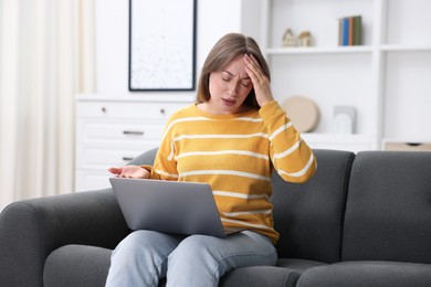 Photo of Sick woman having online consultation with doctor via laptop on sofa at home