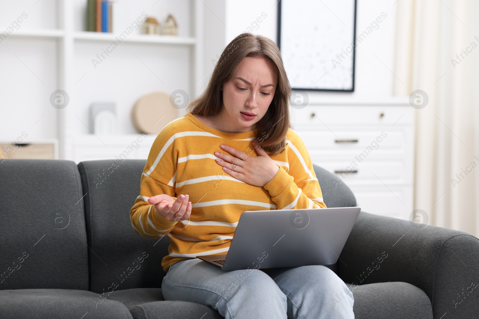 Sick woman having online consultation with doctor via laptop on sofa at home Photo of Sick woman having online consultation with doctor via laptop on sofa at home