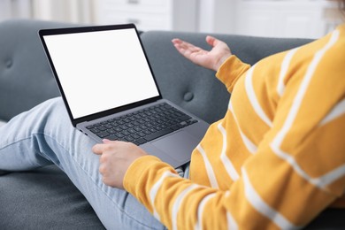Photo of Woman having online consultation with doctor via laptop on sofa at home, closeup