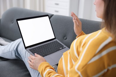 Photo of Woman having online consultation with doctor via laptop on sofa at home, closeup
