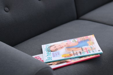 Photo of Lifestyle magazines on sofa indoors, closeup view