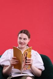 Photo of Woman with fashion magazine on armchair against red background, space for text
