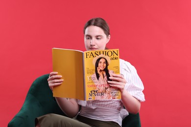 Photo of Woman with fashion magazine on armchair against red background