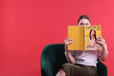 Photo of Woman with fashion magazine on armchair against red background, space for text