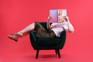 Photo of Woman with lifestyle magazine on armchair against red background