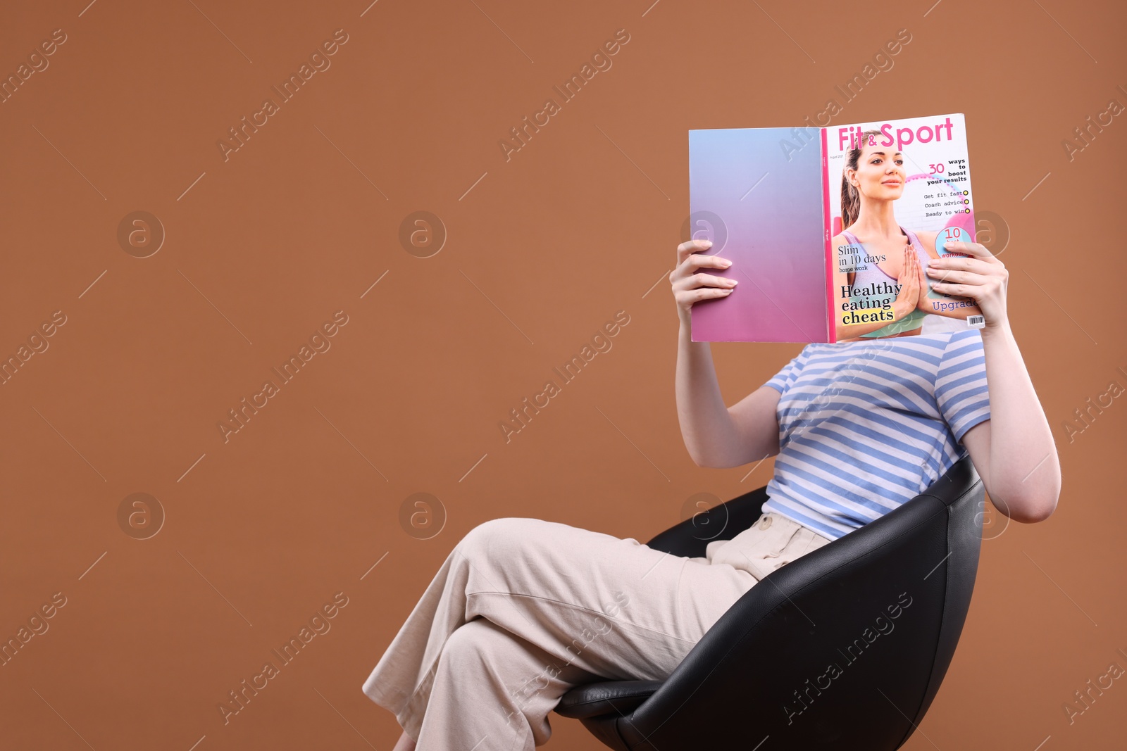 Woman with lifestyle magazine on armchair against brown background, space for text Photo of Woman with lifestyle magazine on armchair against brown background, space for text