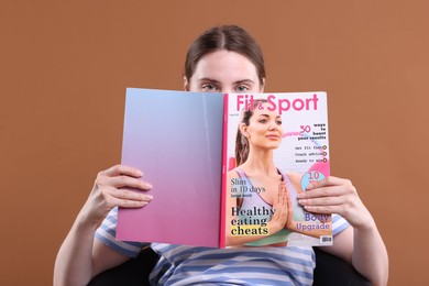 Photo of Woman with lifestyle magazine on armchair against brown background