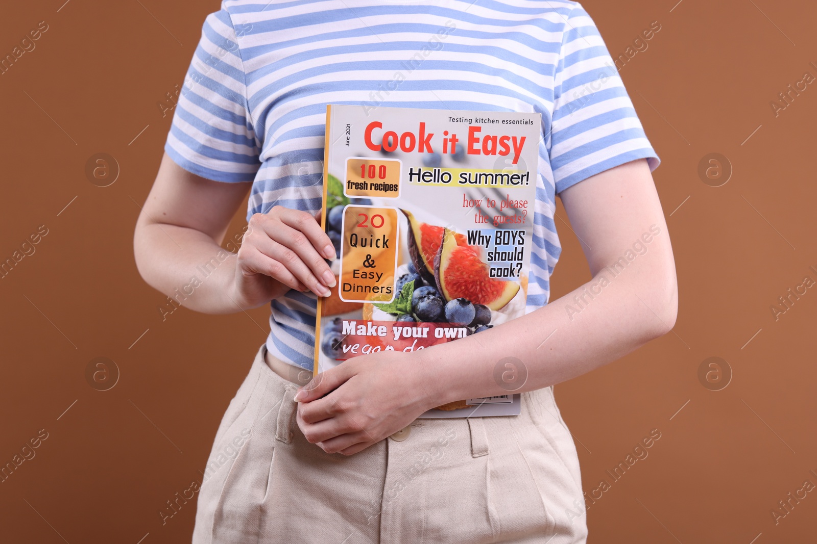 Woman with lifestyle magazine on brown background, closeup Photo of Woman with lifestyle magazine on brown background, closeup