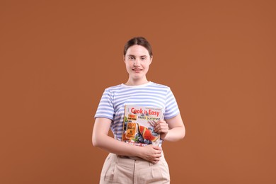 Photo of Woman with lifestyle magazine on brown background
