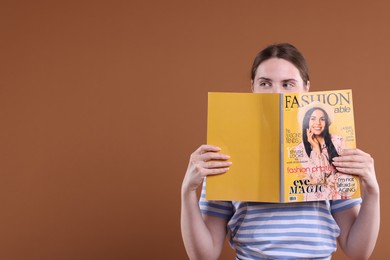 Photo of Woman with fashion magazine on brown background, space for text