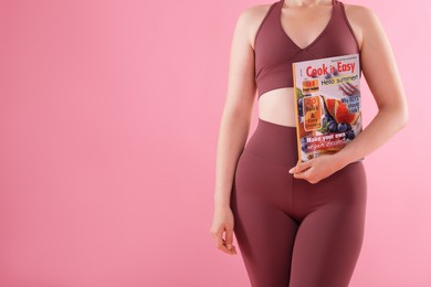 Photo of Woman with lifestyle magazine on pink background, closeup. Space for text