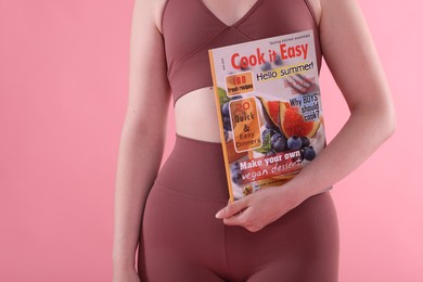 Photo of Woman with lifestyle magazine on pink background, closeup