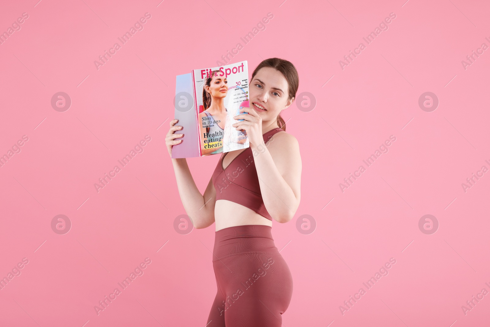 Woman with lifestyle magazine on pink background Photo of Woman with lifestyle magazine on pink background