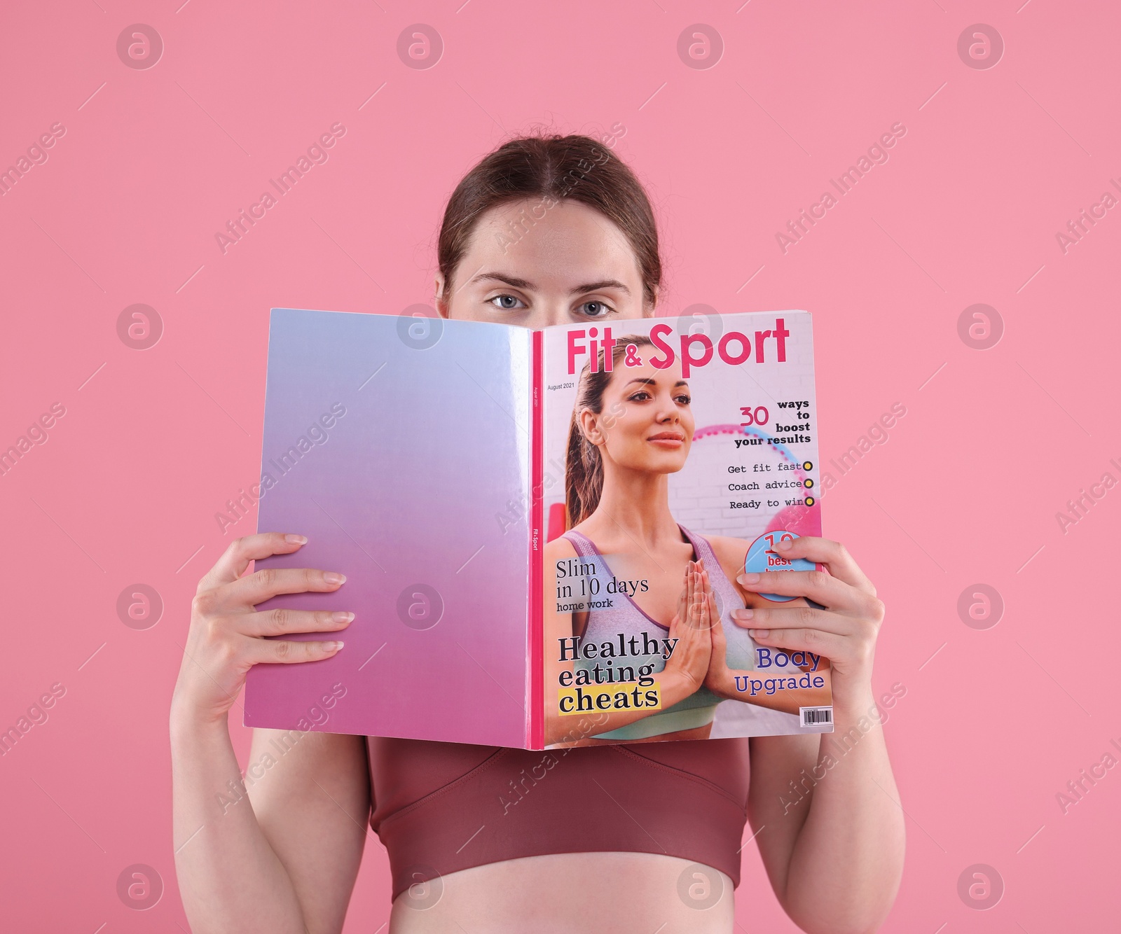Woman with lifestyle magazine on pink background Photo of Woman with lifestyle magazine on pink background
