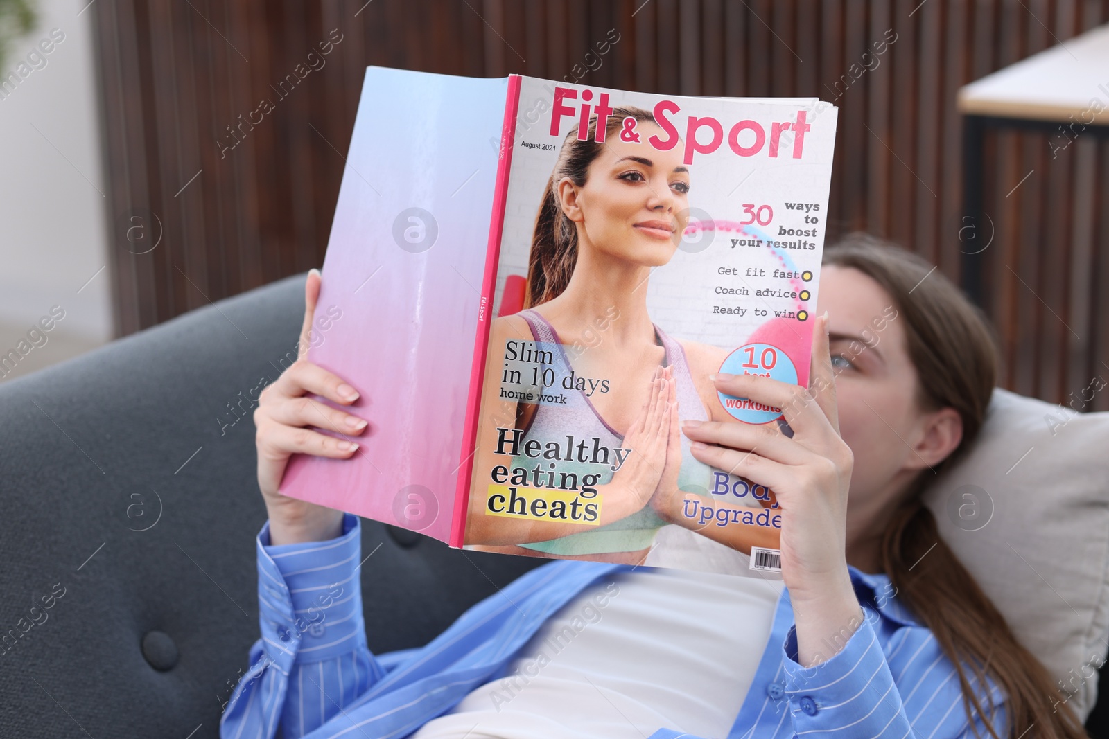 Woman reading lifestyle magazine on sofa at home Photo of Woman reading lifestyle magazine on sofa at home