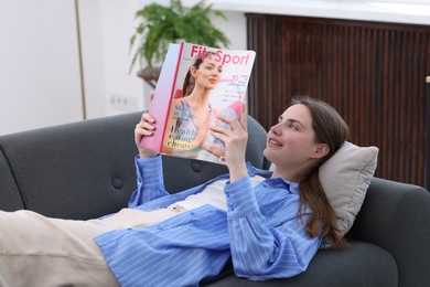 Photo of Woman reading lifestyle magazine on sofa at home