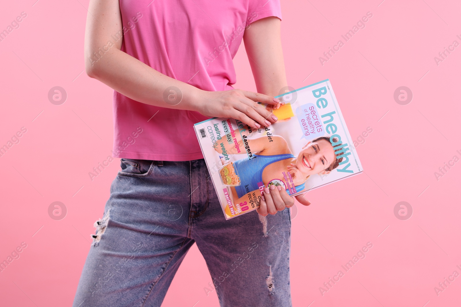 Woman with lifestyle magazine on pink background, closeup Photo of Woman with lifestyle magazine on pink background, closeup