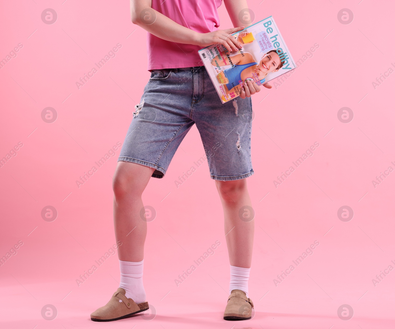 Woman with lifestyle magazine on pink background, closeup Photo of Woman with lifestyle magazine on pink background, closeup