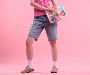 Photo of Woman with lifestyle magazine on pink background, closeup
