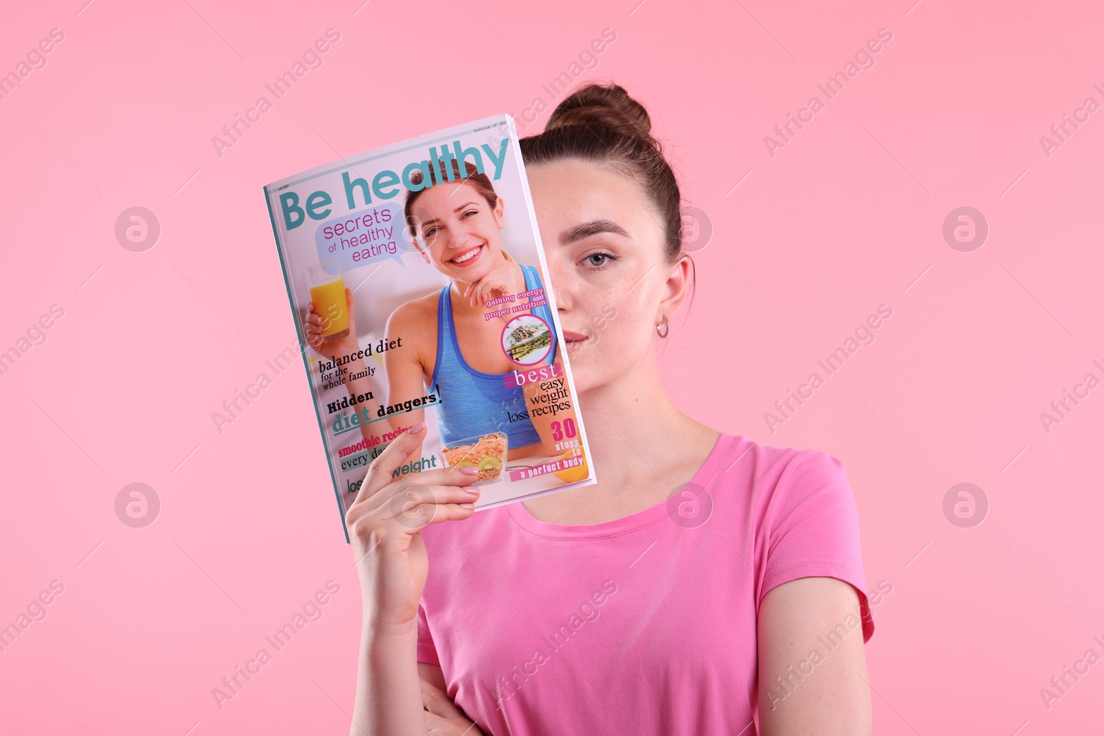 Woman with lifestyle magazine on pink background Photo of Woman with lifestyle magazine on pink background