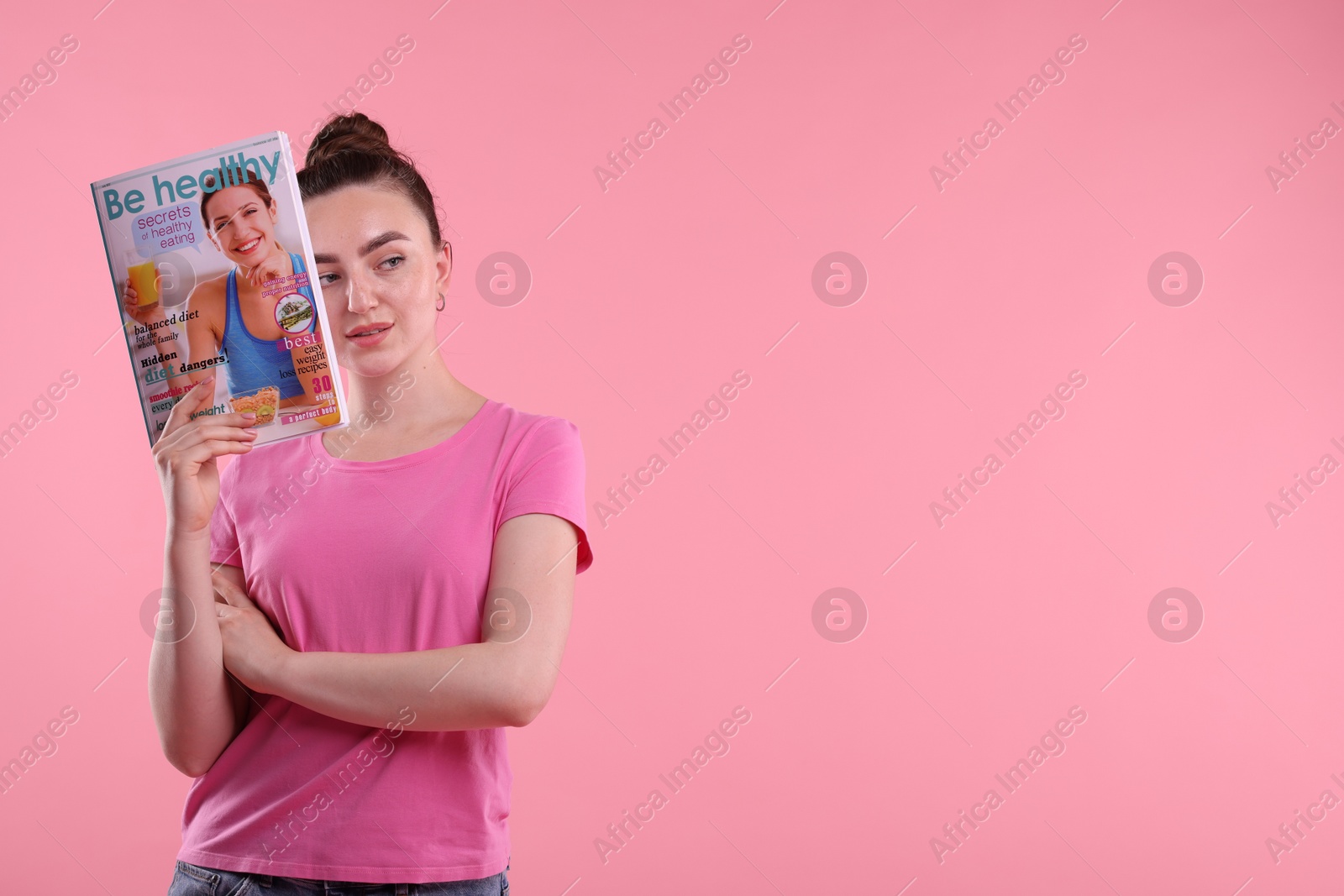 Woman with lifestyle magazine on pink background, space for text Photo of Woman with lifestyle magazine on pink background, space for text