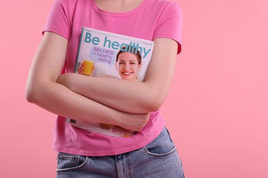 Photo of Woman with lifestyle magazine on pink background, closeup