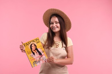 Photo of Woman with fashion magazine on pink background