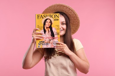 Photo of Woman with fashion magazine on pink background