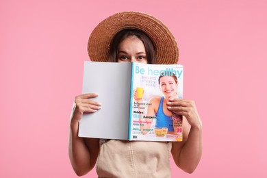 Photo of Woman with lifestyle magazine on pink background
