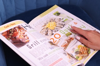 Photo of Woman with lifestyle magazine on armchair, closeup