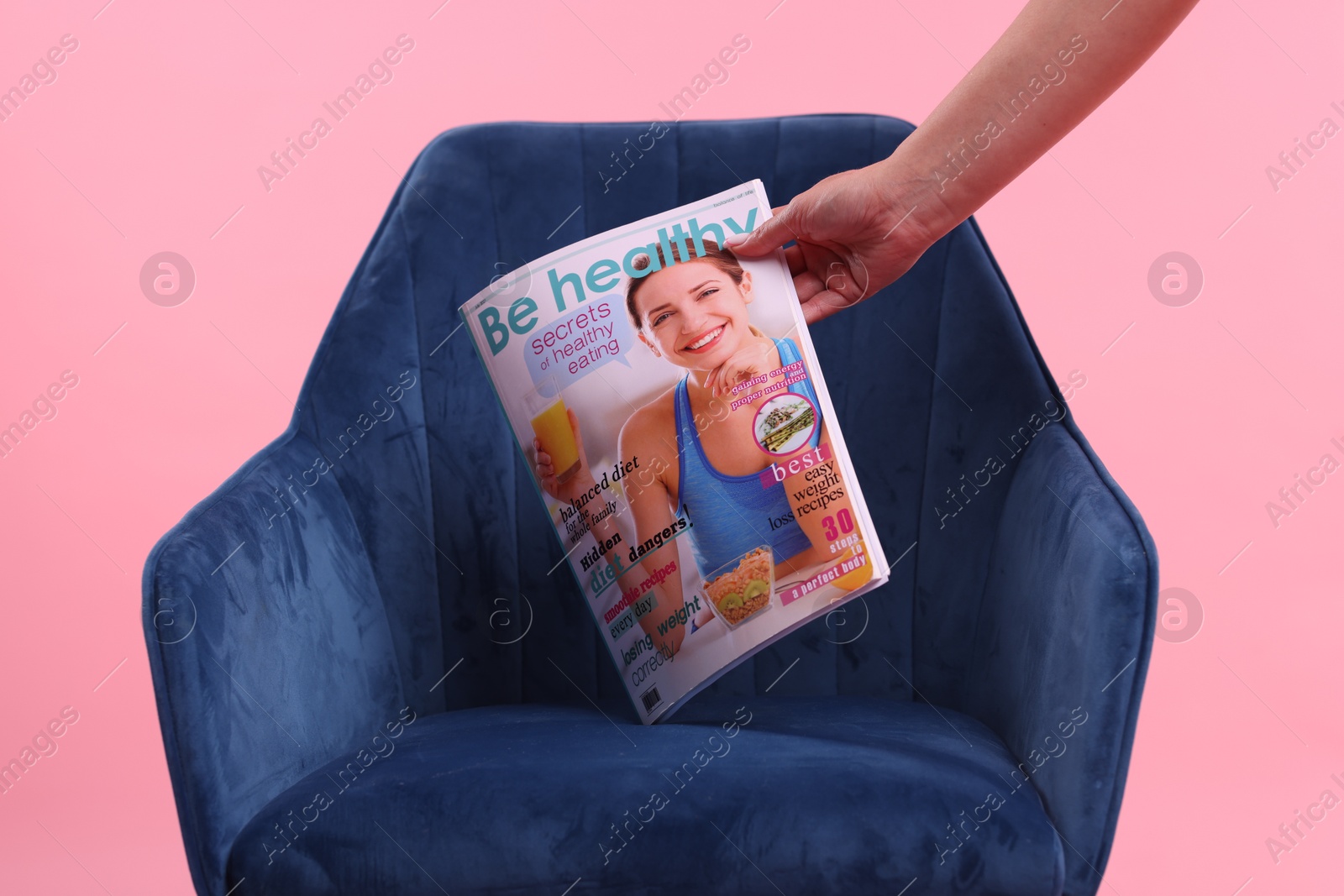 Woman with lifestyle magazine and armchair on pink background, closeup Photo of Woman with lifestyle magazine and armchair on pink background, closeup