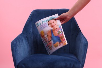 Photo of Woman with lifestyle magazine and armchair on pink background, closeup