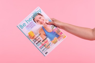 Photo of Woman with lifestyle magazine on pink background, closeup