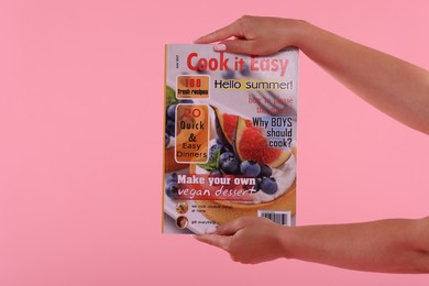 Photo of Woman with lifestyle magazine on pink background, closeup