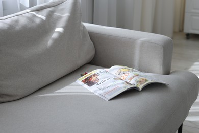 Photo of Lifestyle magazines on sofa indoors, closeup view