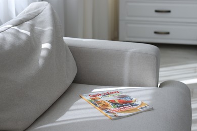 Photo of Lifestyle magazines on sofa indoors, closeup view