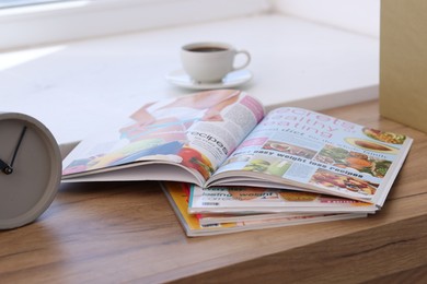 Photo of Lifestyle magazines on wooden table indoors, closeup