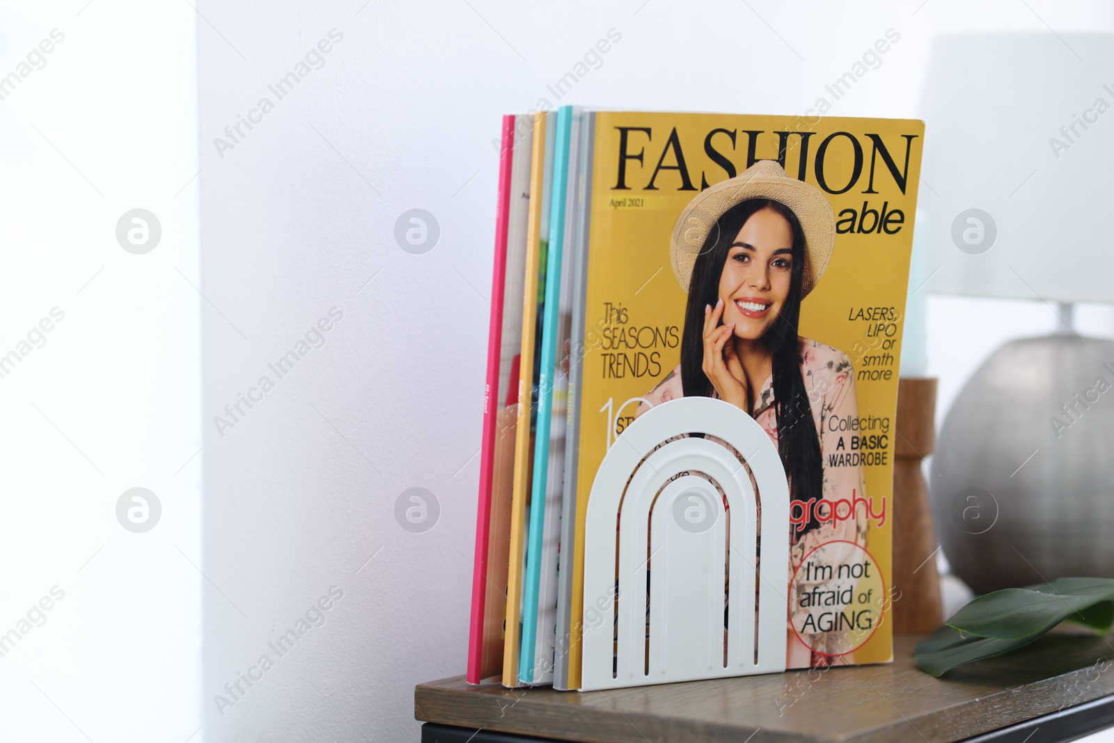 Lifestyle magazines on wooden table indoors, closeup. Space for text Photo of Lifestyle magazines on wooden table indoors, closeup. Space for text