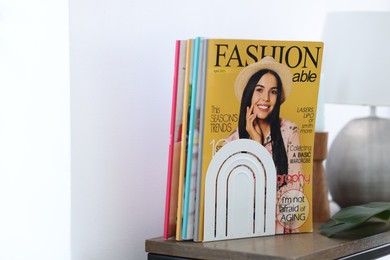 Photo of Lifestyle magazines on wooden table indoors, closeup. Space for text