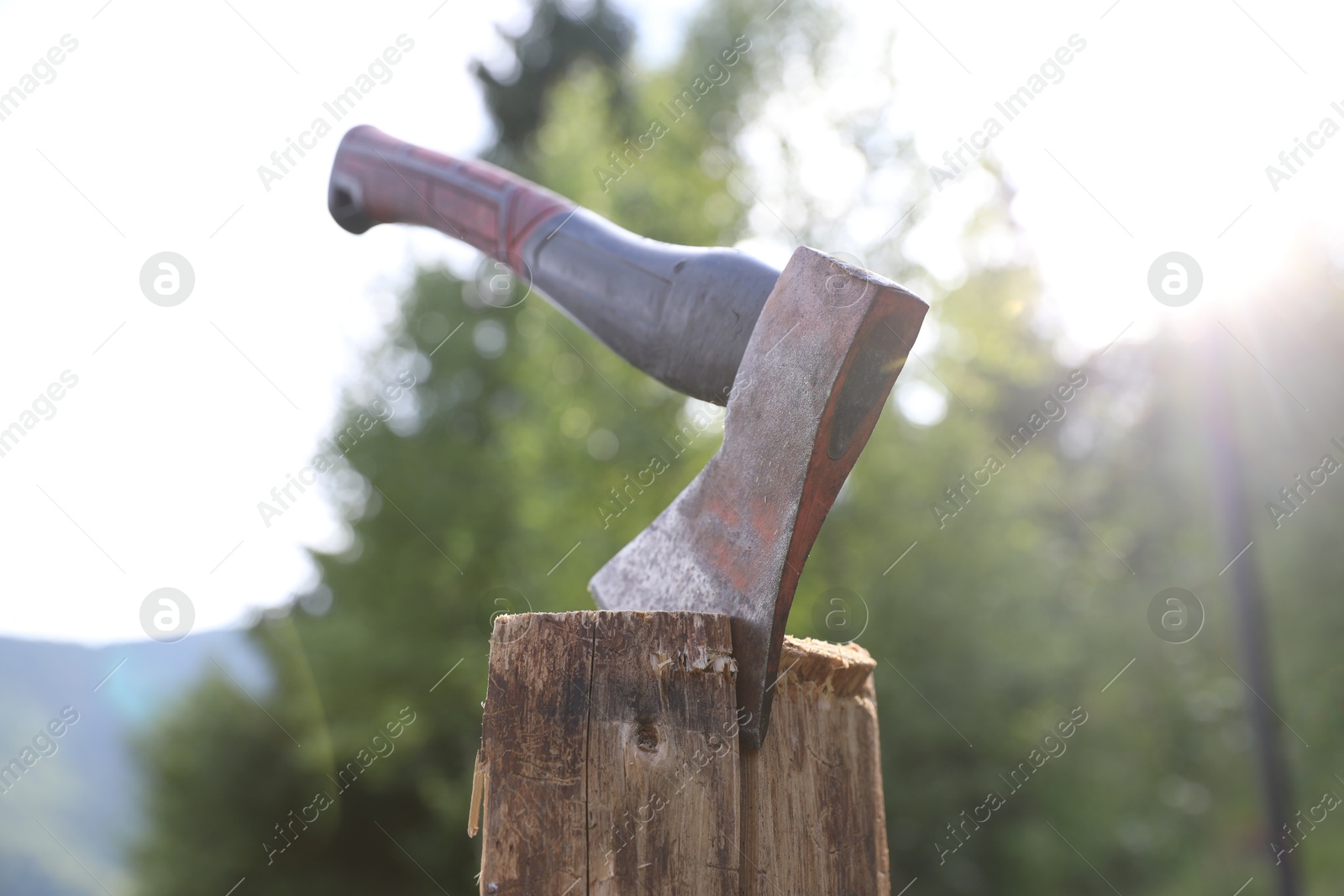 Metal axe on wooden log outdoors, closeup Photo of Metal axe on wooden log outdoors, closeup